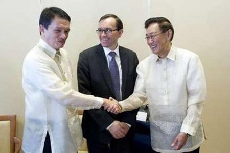 Đại diện của chính phủ Philippines, ông Alexander A. Padilla (trái) và đại diện của NDF, ông Luis G. Jalandoni, bắt tay chào nhau trước sự chứng kiến của “đạo diễn chính trị” Espen Barth Eide của Bộ Ngoại giao Na Uy trước khi các cuộc đàm phán hòa bình được khôi phục ở Asker, phía nam Oslo, Na Uy.