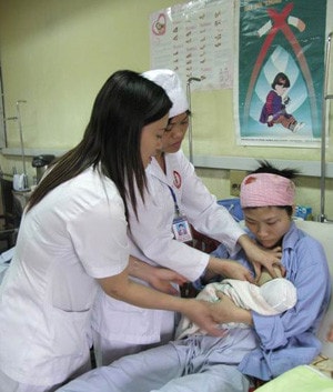 Điều dưỡng viên hướng dẫn bà mẹ cho con bú