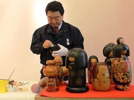 Nghệ nhân Masaru Aoki đang phục chế bộ búp bê gỗ Kokeshi