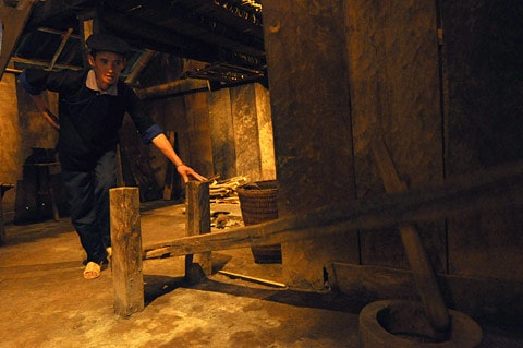 Nhà người H'Mông làm bằng gỗ nhưng lợp tranh, riêng ở huyện Mù Căng Chải, tỉnh Yên Bái lại có nét độc đáo riêng biệt là toàn bộ nhà được làm bằng gỗ pơmu. Tiến sĩ Vi Văn An đã trực tiếp tìm kiếm, đưa ngôi nhà này từ bản Đề Chờ Chua, xã Púng Luông về dựng tại Bảo tàng từ năm 1999. Mặt trước... ...và mặt sau ngôi nhà Mặt bên trái, thường là nơi để nước sinh hoạt Mặt bên phải, nhà người H'Mông thường để Cối xay ngô Theo tiến sĩ Vi Văn An, bảo tàng đã sử dụng tới khảng gần 700 tấm gỗ để lợp lại toàn bộ phần mái nhà chính, nhà nuôi gia súc, nhà lò rèn đúc lưỡi cày. Các tấm gỗ loại này phải tìm, đặt trước với người làng ở Púng Luông vì bây giờ người H'Mông đã lợp prôximăng. Nét độc đáo trong kiến trúc ngôi nhà của người H'Mông tương đối thống nhất theo một khuôn mẫu, dù to hay nhỏ đều phải có ba gian, nhà hầu như không có cửa sổ, chỉ có 2 cửa là cửa chính và cửa phụ dành cho phụ nữ. Điểm độc đáo này cho thấy sự thích ứng của người H'Mông ở vùng thời tiết lạnh Theo ông Lù Vàng Sa người dân tộc H'Mông cho biết đối với hai cây cột cái ở gian giữa và cây cái nóc, người H'Mông coi hai cây cột cái là cột chủ đạo trong nhà thể hiện sự ngay thẳng, cứng cáp, vững vàng của chủ nhà, nên cây cột phải là một cây rừng không bị sâu, thối, cụt ngọn Gian bên phải dùng để đặt giường khách... ...và bếp sưởi Gian bên trái dùng để đặt bếp nấu nướng... ...và buồng ngủ của vợ chồng gia chủ Gian giữa thường rộng hơn hai gian bên và là gian để bàn thờ tổ tiên, đồng thời cũng là nơi tiếp khách, ăn uống của gia đình. Chiếc Cối giã gạo... ...và đồ dùng đi làm nương thường được để hai bên góc của gian giữa ở cạnh cửa chính của ngôi nhà Chiếc máy dệt của người H'Mông Những đạo cụ âm nhạc của người H'Mông Trong đời sống hàng ngày, vui hay buồn, người H'Mông cũng mang khèn ra thổi. Người H'Mông thường thổi khèn khi xuống chợ, khi đi tìm người yêu và trong các lễ hội. Nhẩy Pao... ...đá Pao ...và đánh Cầu lông gà thường xuất hiện vào mồng 1 Tết của người H'Mông Nhà nuôi gia súc... ... và nhà lò rèn đúc lưỡi cày của người H'Mông Sản phẩm lưỡi cày của người H'Mông