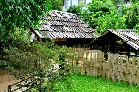 Nhà người H'Mông làm bằng gỗ nhưng lợp tranh, riêng ở huyện Mù Căng Chải, tỉnh Yên Bái lại có nét độc đáo riêng biệt là toàn bộ nhà được làm bằng gỗ pơmu. Tiến sĩ Vi Văn An đã trực tiếp tìm kiếm, đưa ngôi nhà này từ bản Đề Chờ Chua, xã Púng Luông về dựng tại Bảo tàng từ năm 1999. Mặt trước... ...và mặt sau ngôi nhà Mặt bên trái, thường là nơi để nước sinh hoạt Mặt bên phải, nhà người H'Mông thường để Cối xay ngô Theo tiến sĩ Vi Văn An, bảo tàng đã sử dụng tới khảng gần 700 tấm gỗ để lợp lại toàn bộ phần mái nhà chính, nhà nuôi gia súc, nhà lò rèn đúc lưỡi cày. Các tấm gỗ loại này phải tìm, đặt trước với người làng ở Púng Luông vì bây giờ người H'Mông đã lợp prôximăng. Nét độc đáo trong kiến trúc ngôi nhà của người H'Mông tương đối thống nhất theo một khuôn mẫu, dù to hay nhỏ đều phải có ba gian, nhà hầu như không có cửa sổ, chỉ có 2 cửa là cửa chính và cửa phụ dành cho phụ nữ. Điểm độc đáo này cho thấy sự thích ứng của người H'Mông ở vùng thời tiết lạnh Theo ông Lù Vàng Sa người dân tộc H'Mông cho biết đối với hai cây cột cái ở gian giữa và cây cái nóc, người H'Mông coi hai cây cột cái là cột chủ đạo trong nhà thể hiện sự ngay thẳng, cứng cáp, vững vàng của chủ nhà, nên cây cột phải là một cây rừng không bị sâu, thối, cụt ngọn Gian bên phải dùng để đặt giường khách... ...và bếp sưởi Gian bên trái dùng để đặt bếp nấu nướng... ...và buồng ngủ của vợ chồng gia chủ Gian giữa thường rộng hơn hai gian bên và là gian để bàn thờ tổ tiên, đồng thời cũng là nơi tiếp khách, ăn uống của gia đình. Chiếc Cối giã gạo... ...và đồ dùng đi làm nương thường được để hai bên góc của gian giữa ở cạnh cửa chính của ngôi nhà Chiếc máy dệt của người H'Mông Những đạo cụ âm nhạc của người H'Mông Trong đời sống hàng ngày, vui hay buồn, người H'Mông cũng mang khèn ra thổi. Người H'Mông thường thổi khèn khi xuống chợ, khi đi tìm người yêu và trong các lễ hội. Nhẩy Pao... ...đá Pao ...và đánh Cầu lông gà thường xuất hiện vào mồng 1 Tết của người H'Mông Nhà nuôi gia súc... ... và nhà lò rèn đúc lưỡi cày của người H'Mông Sản phẩm lưỡi cày của người H'Mông