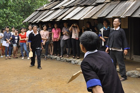 Nhà người H'Mông làm bằng gỗ nhưng lợp tranh, riêng ở huyện Mù Căng Chải, tỉnh Yên Bái lại có nét độc đáo riêng biệt là toàn bộ nhà được làm bằng gỗ pơmu. Tiến sĩ Vi Văn An đã trực tiếp tìm kiếm, đưa ngôi nhà này từ bản Đề Chờ Chua, xã Púng Luông về dựng tại Bảo tàng từ năm 1999. Mặt trước... ...và mặt sau ngôi nhà Mặt bên trái, thường là nơi để nước sinh hoạt Mặt bên phải, nhà người H'Mông thường để Cối xay ngô Theo tiến sĩ Vi Văn An, bảo tàng đã sử dụng tới khảng gần 700 tấm gỗ để lợp lại toàn bộ phần mái nhà chính, nhà nuôi gia súc, nhà lò rèn đúc lưỡi cày. Các tấm gỗ loại này phải tìm, đặt trước với người làng ở Púng Luông vì bây giờ người H'Mông đã lợp prôximăng. Nét độc đáo trong kiến trúc ngôi nhà của người H'Mông tương đối thống nhất theo một khuôn mẫu, dù to hay nhỏ đều phải có ba gian, nhà hầu như không có cửa sổ, chỉ có 2 cửa là cửa chính và cửa phụ dành cho phụ nữ. Điểm độc đáo này cho thấy sự thích ứng của người H'Mông ở vùng thời tiết lạnh Theo ông Lù Vàng Sa người dân tộc H'Mông cho biết đối với hai cây cột cái ở gian giữa và cây cái nóc, người H'Mông coi hai cây cột cái là cột chủ đạo trong nhà thể hiện sự ngay thẳng, cứng cáp, vững vàng của chủ nhà, nên cây cột phải là một cây rừng không bị sâu, thối, cụt ngọn Gian bên phải dùng để đặt giường khách... ...và bếp sưởi Gian bên trái dùng để đặt bếp nấu nướng... ...và buồng ngủ của vợ chồng gia chủ Gian giữa thường rộng hơn hai gian bên và là gian để bàn thờ tổ tiên, đồng thời cũng là nơi tiếp khách, ăn uống của gia đình. Chiếc Cối giã gạo... ...và đồ dùng đi làm nương thường được để hai bên góc của gian giữa ở cạnh cửa chính của ngôi nhà Chiếc máy dệt của người H'Mông Những đạo cụ âm nhạc của người H'Mông Trong đời sống hàng ngày, vui hay buồn, người H'Mông cũng mang khèn ra thổi. Người H'Mông thường thổi khèn khi xuống chợ, khi đi tìm người yêu và trong các lễ hội. Nhẩy Pao... ...đá Pao ...và đánh Cầu lông gà thường xuất hiện vào mồng 1 Tết của người H'Mông Nhà nuôi gia súc... ... và nhà lò rèn đúc lưỡi cày của người H'Mông Sản phẩm lưỡi cày của người H'Mông