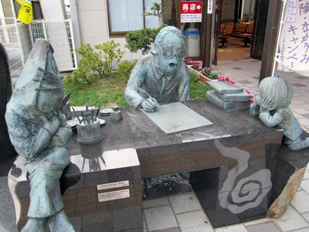 Tác giả Yoichi Takahashi bên tượng nhân vật thủ quân Tượng xứ sở Yêu Ma
