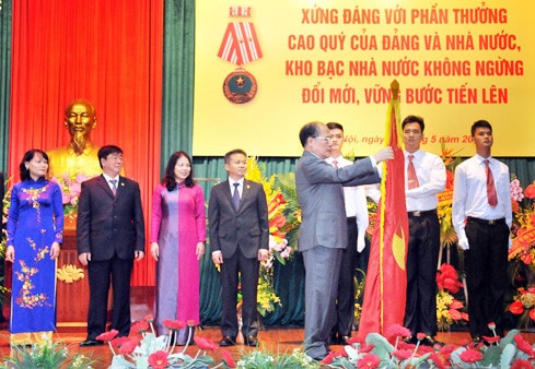 Chủ tịch QH Nguyễn Sinh Hùng gắn Huân chương Độc lập hạng Nhì lên lá cờ truyền thống của Kho bạc Nhà nước