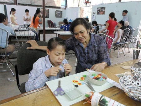 Giám đốc Trung tâm Vì ngày mai, bà Lê Minh Hiền động viên, hướng dẫn một học viên khuyết tật học nghề Nguồn: tuthien.vn