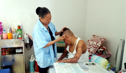 Bà Trịnh Thị Đông - mẹ của chiến sỹ Đinh Văn Dương luôn túc trực bên con trai Ảnh: Phượng Hoàng