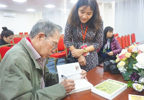 Nhà văn Ma Văn Kháng ký tặng sách độc giả Ảnh: Thái Minh
