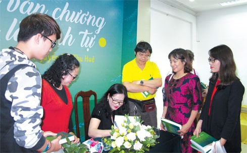 Nhà văn Nguyễn Thị Thu Huệ ký tặng độc giả nhân dịp ra mắt tuyển tập “Của để dành” Ảnh: K.Linh