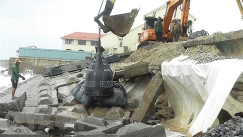 Phần thân kè, đoạn tiếp giáp với nước biển được gia cường bằng túi cát lớn. (Ảnh: Hữu Trung/TTXVN)