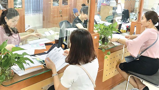 Cán bộ BHXH TP Hà Nội hướng dẫn người tham gia BHXH hoàn thiện thủ tục Nguồn: ITN