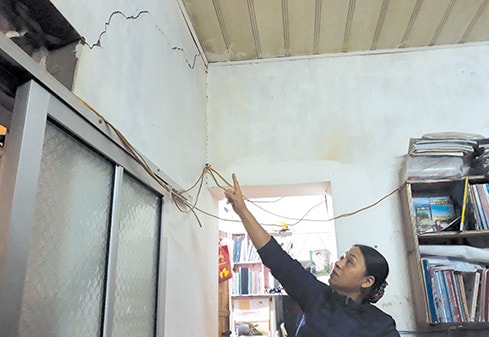 Bà Phạm Thị Duyên chỉ lên vết tường nứt nham nhở được cho là do thi công đường dẫn vào Depot Ảnh: Đan Thanh