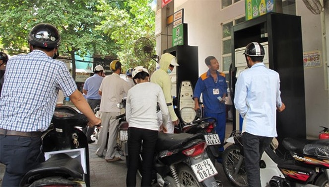 Nhân viên Petrolimex đang bán xăng cho khách hàng. Ảnh nguồn: TTXVN