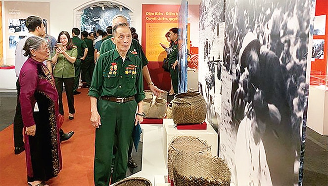 Ông Đỗ Bính xem lại những hình ảnh và kỷ vật tại triển lãm “Dân công hỏa tuyến trong chiến dịch Điện Biên Phủ”