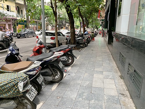 Xe máy được xếp thành hàng lối theo vạch trên vỉa hè phố Nhà Thờ