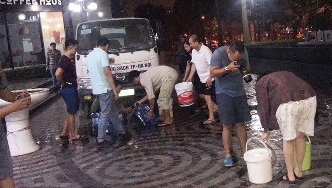 Người dân hứng nước từ các xe téc.