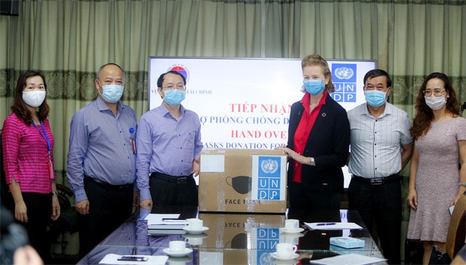 Đại Diện thường trú của UNDP Caitlin Wiesen trao khẩu trang cho đại diện Bộ Y tế