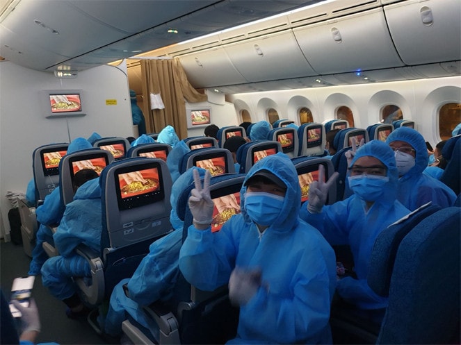 Các hành khách thể hiện tâm trạng phấn khởi trên chuyến bay về nước