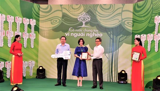 Đại diện Vietcombank, bà Phùng Nguyễn Hải Yến – Phó Bí thư Đảng ủy TSC, Phó Tổng Giám đốc, Chủ tịch Công đoàn TSC (đứng giữa) trao tượng trưng số tiền 3 tỷ đồng của Vietcombank ủng hộ người nghèo cho Chủ tịch UBTW MTTQ Việt Nam Trần Thanh Mẫn (bên trái) và nhận Kỷ niệm chương vinh danh của BTC từ Phó Thủ tướng Chính phủ Vũ Đức Đam