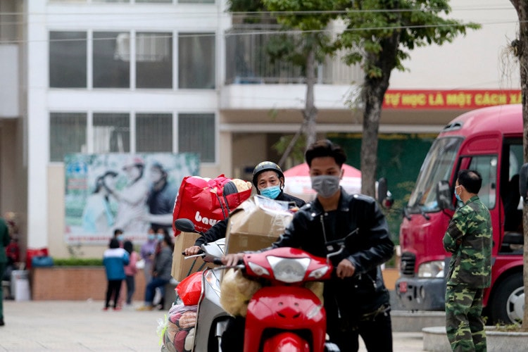 Người nhà vận chuyển đồ đạc sau những ngày cách ly tại trường.