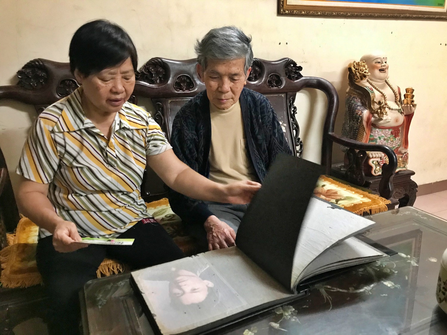 hai vợ chồng ông bà Lê Viết Phụng và Lê Thị Ngừng đang cùng nhau xem lại tập ảnh kỷ niệm về những năm tháng bà đã cống hiến tuổi thanh xuân, góp phần nhỏ bé xây dựng nên công trường TNCS đầu tiên
