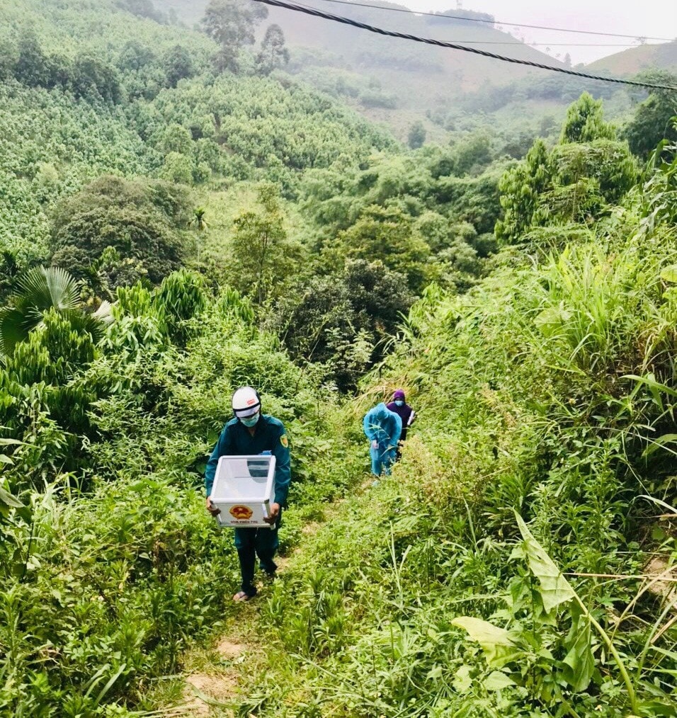Lực lượng làm nhiệm vụ ôm hòm phiếu băng rừng đến phục vụ cử tri bị cách ly do Covid-19 (F1)