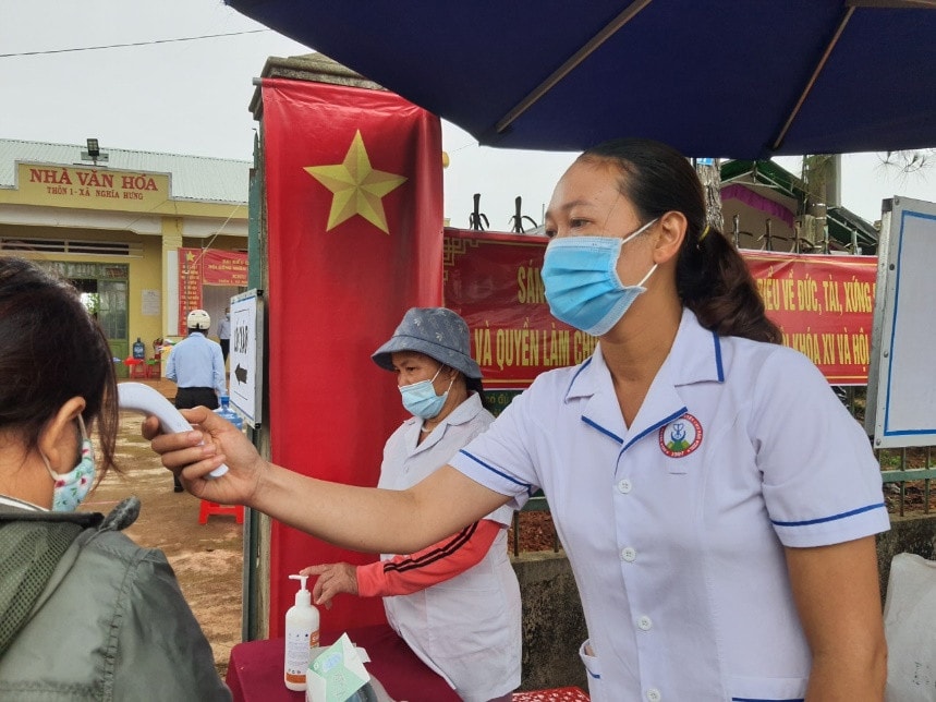 Cán bộ y tế có mặt từ sớm để hoàn thành công việc khử khuẩn, phát khẩu trang và đo thân nhiệt