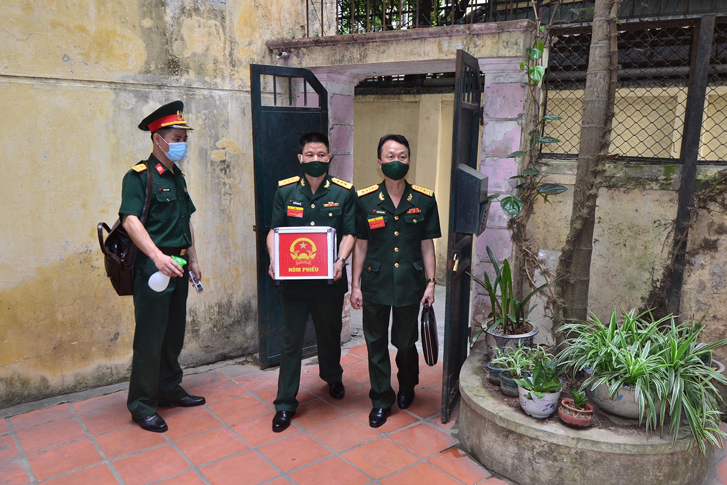 	Cán bộ Tổ bầu cử Khu vực bỏ phiếu số 11, phường Điện Biên, quận Ba Đình, Hà Nội mang hòm phiếu phụ đến nhà Đại tướng Nguyễn (99 tuổi) để phát phiếu bầu và tiến hành bỏ phiếu tại nhà