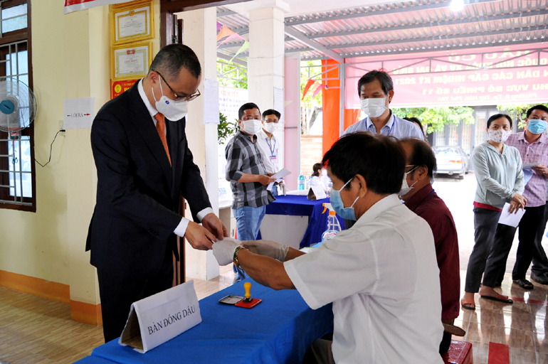 Bí thư Tỉnh ủy Phạm Đại Dương nhận lại phiếu cử tri sau khi đã hoàn thành bầu cử. Ảnh: ANH NGỌC