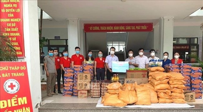 Hội Chữ thập đỏ huyện Gia Lâm trao hỗ trợ tới người dân có hoàn cảnh khó khăn và lực lượng tuyến đầu chống dịch của xã Bát Tràng. Ảnh: TTXVN