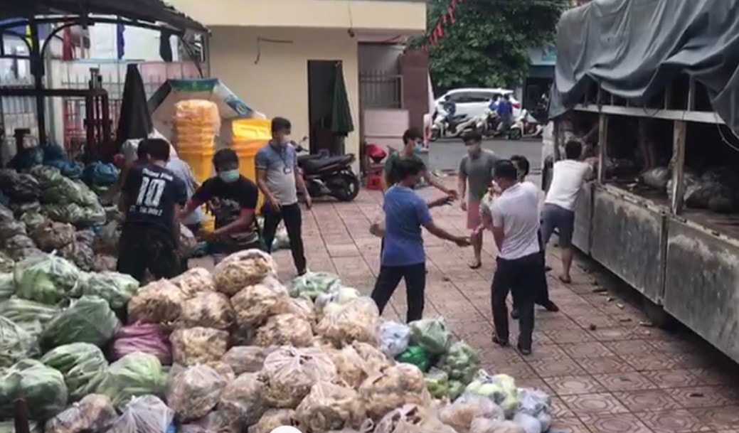 Các tình nguyện viên hỗ trợ chuyển rau củ quả cho công nhân tại Phường Long Bình