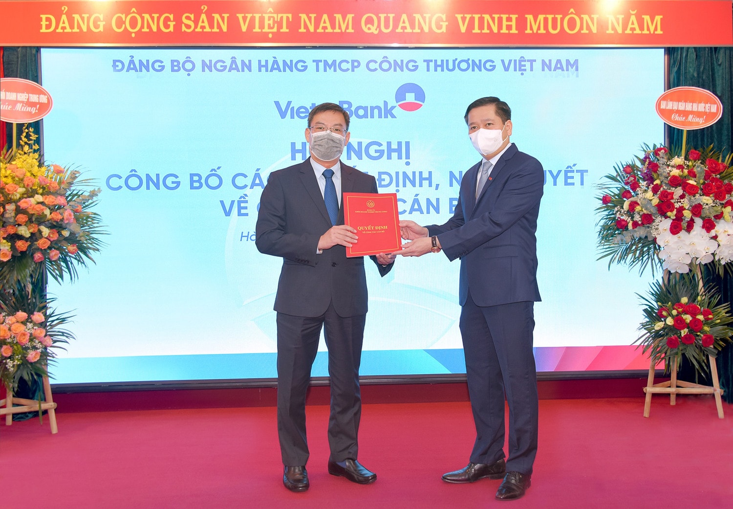 Đc Nguyễn Long Hải - Ủy viên Dự khuyết BCH Trung ương Đảng, Bí thư Đảng ủy Khối DNTW trao quyết định và tặng hoa chúc mừng đồng chí Trần Minh Bình - tân Bí thư Đảng ủy VietinBank (1).jpg