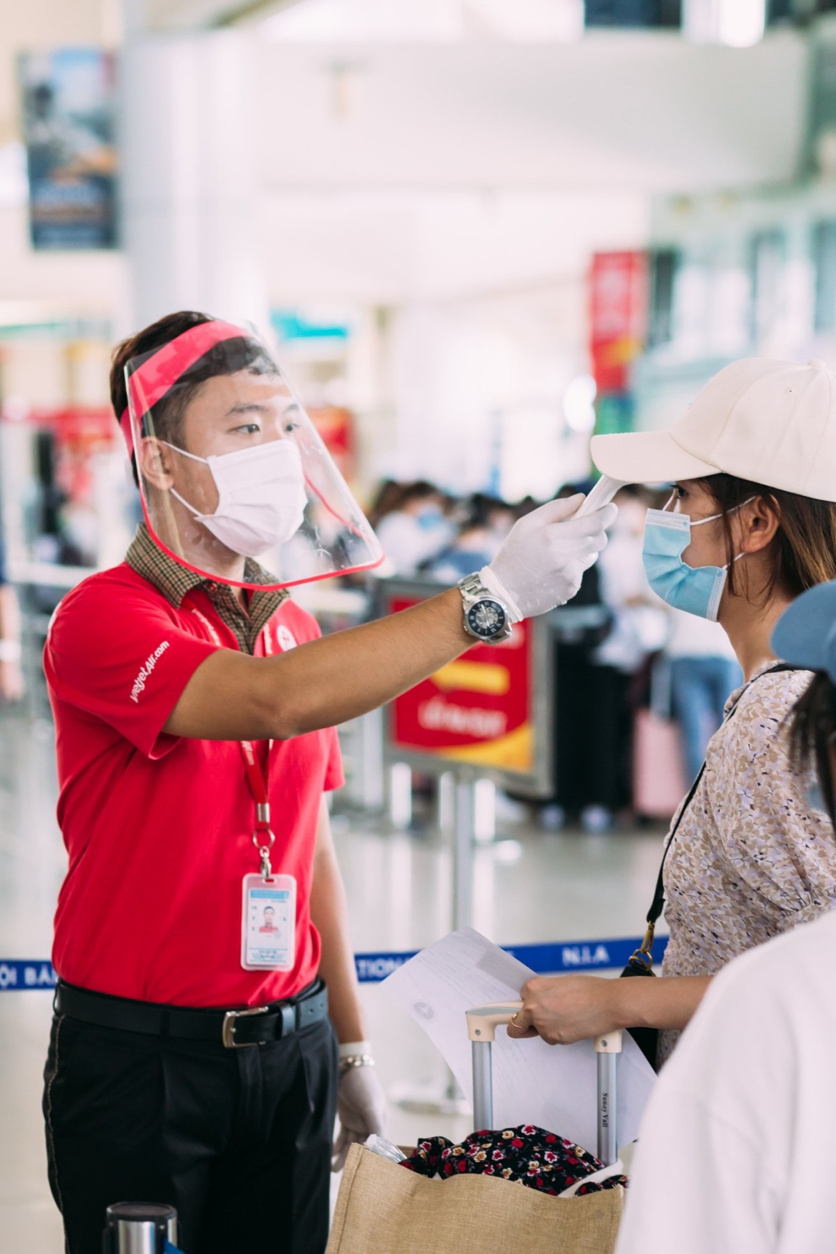 Nhân viên Vietjet thực hiện quy định phòng, chống dịch đối với hành khách trước khi bay