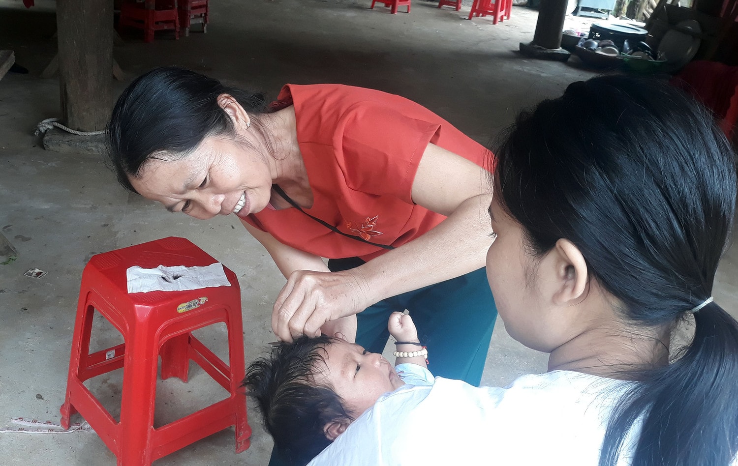 	Bà mối làm lễ cắt tóc cho cháu Vi Minh Long - Ảnh Hữu Vi