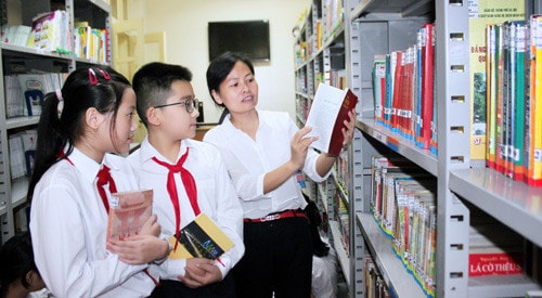 Hướng dẫn học sinh tra cứu sách tại thư viện Trường Tiểu học Trần Quốc Toản Ảnh: Bùi Tuấn