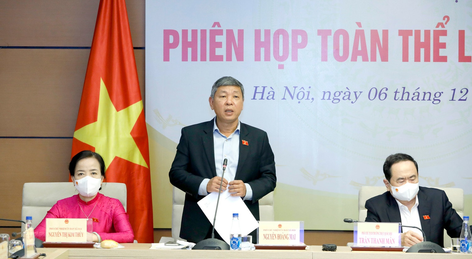 Phó Chủ nhiệm Ủy ban Xã hội Nguyễn Hoàng Mai trình bày dự thảo báo cáo thẩm tra dự thảo Nghị quyết Ảnh: Hồ Long