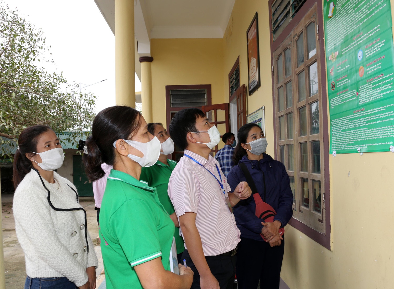 Cán bộ tín dụng PGD NHCSXH huyện Con Cuông hướng dẫn người lao động hồi hương vay vốn Ảnh: Đức Kiên