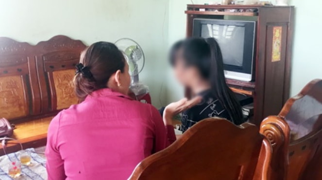 Một bé gái là nạn nhân một vụ xâm hại tình dục (phải) đang tường thuật sự việc với cán bộ Lao động - thương binh và xã hội.