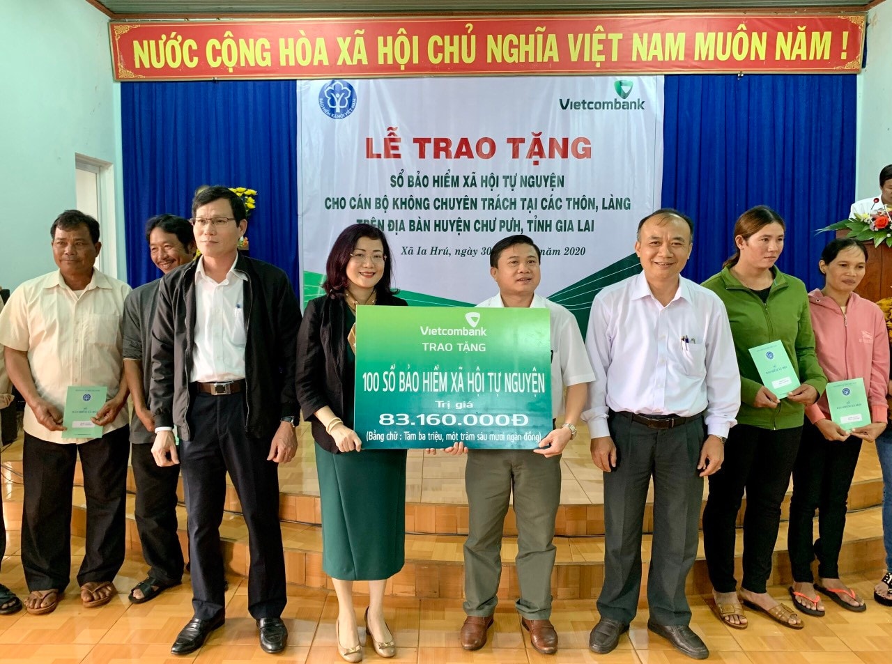 Bà Đỗ Thị Việt Hằng - Giám đốc Vietcombank Chi nhánh Gia Lai trao bảng tượng trưng tặng sổ BHXH tự nguyện cho đại diện UBND huyện Chư Pưh Ảnh: Như Nguyện
