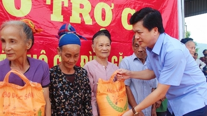Bí thư Huyện ủy Con Cuông Nguyễn Đình Hùng trao gạo cho các hộ nghèo. ảnh B.HẬU