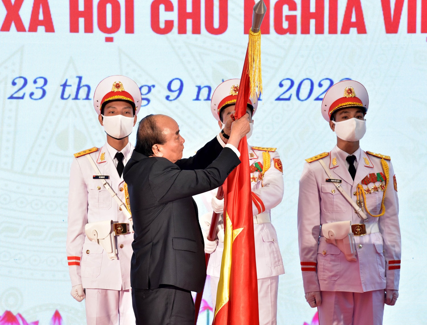 Chủ tịch Nước Nguyễn Xuân Phúc gắn Huân chương Lao động hạng Nhất lên lá cờ truyền thống của Ủy ban Quốc phòng và An ninh của Quốc hội. Ảnh: Lâm Hiển Chủ tịch Nước Nguyễn Xuân Phúc, Chủ tịch Quốc hội Vương Đình Huệ dự kỷ niệm 30 năm thành lập Ủy ban Quốc phòng và An ninh -0