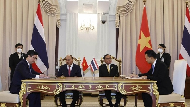 Đại diện Vietcombank (bên trái) và đại diện Eximbank Thái Lan (bên phải) ký kết thỏa thuận hợp tác trước sự chứng kiến của Chủ tịch Nước Nguyễn Xuân Phúc và Thủ tướng Thái Lan Prayuth Chan-ocha. Ảnh: TTXVN