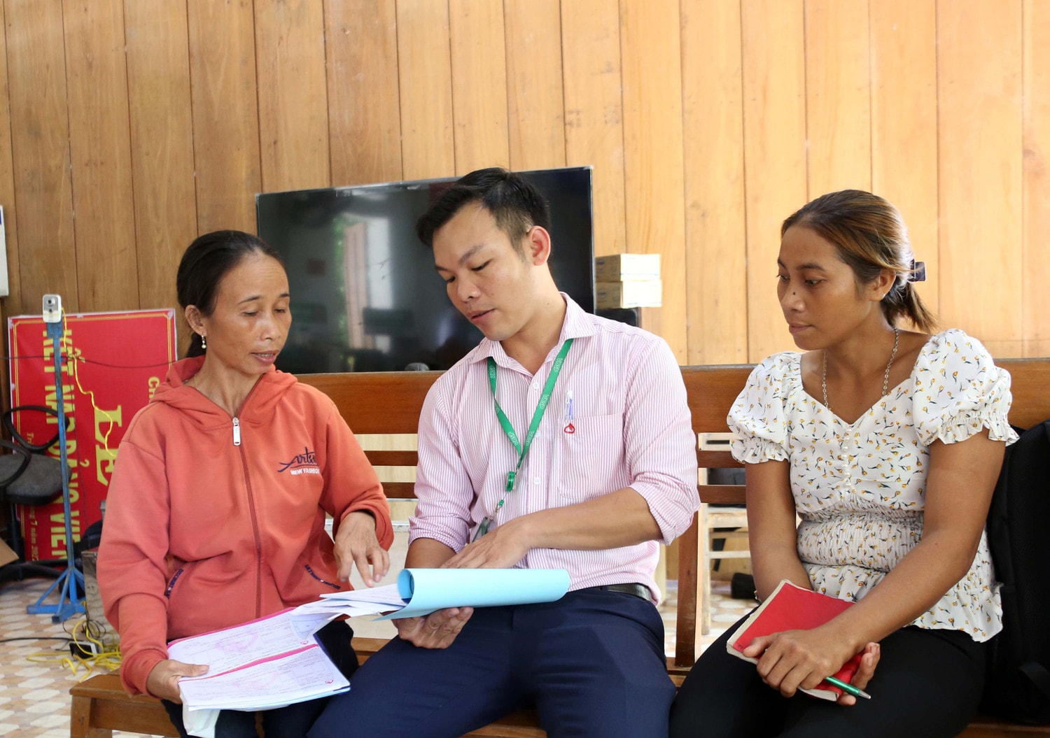 Tổ trưởng Tổ Tiết kiệm và Vay vốn Hồ Thị Mãi (trái) trao đổi tình hình hộ vay với cán bộ NHCSXH huyện Bắc Trà My