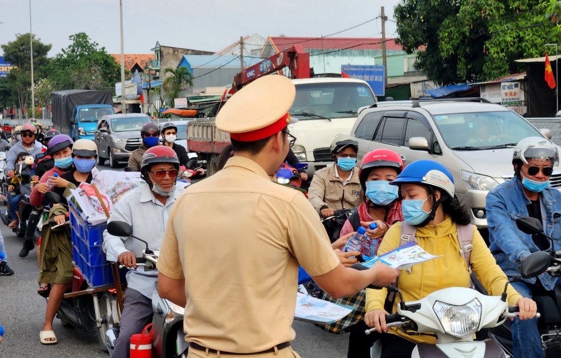 CSGT phát tờ rơi tuyên truyền luật giao thông đường bộ đến người dân. Đang về quê đón Tết, bất ngờ được CSGT phát mũ bảo hiểm, nước uống, khăn lạnh