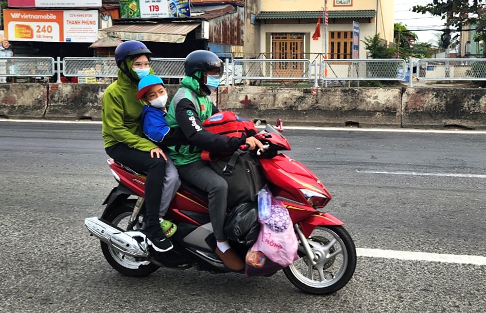 Người dân lỉnh kỉnh đồ đạc rời TP. Hồ Chí Minh về quê ở các tỉnh miền Tây đón Tết. Đang về quê đón Tết, bất ngờ được CSGT phát mũ bảo hiểm, nước uống, khăn lạnh