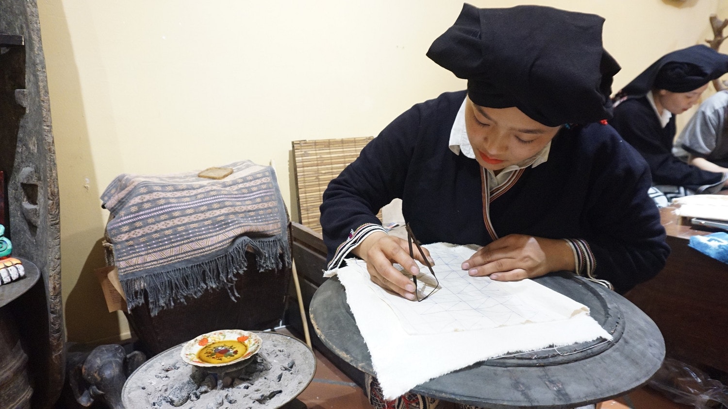 Phụ nữ Dao Tiền vẽ sáp ong lên vải - Ảnh: Thái Minh