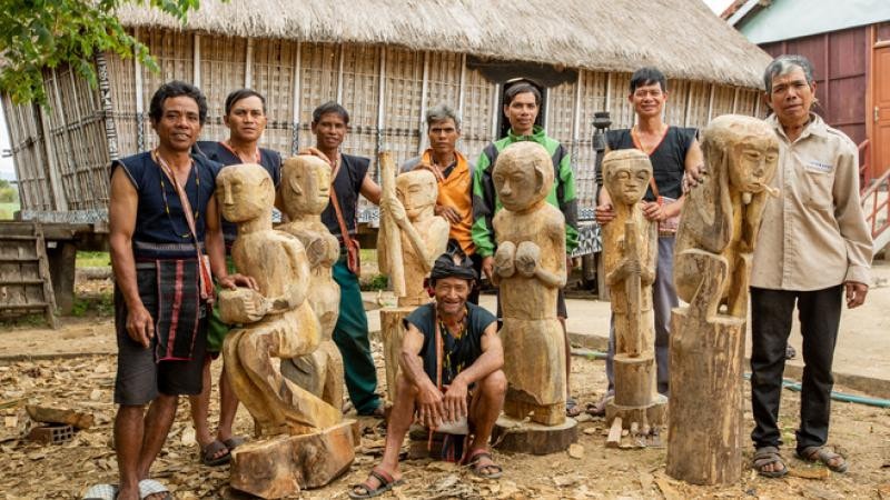 Dân làng Mơ H’ra, Gia Lai bên cạnh những bức tượng truyền thống. Ảnh: Hội đồng Anh