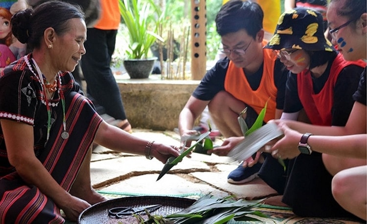 Phụ nữ Pa Cô hướng dẫn du khách trải nghiệm làm bánh. Ảnh: hoilhpn.org.vn