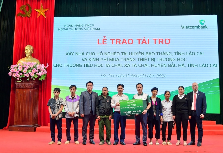 Ông Lê Hoàng Tùng - Phó Tổng Giám đốc Vietcombank (thứ 5 từ phải sang) cùng ông Đặng Việt Hùng - Bí thư Chi bộ, Giám đốc Vietcombank Lào Cai (ngoài cùng bên phải) trao biểu trưng số tiền 300 triệu đồng cho 6 hộ gia đình khó khăn tại huyện Bảo Thắng. Ảnh: VCB