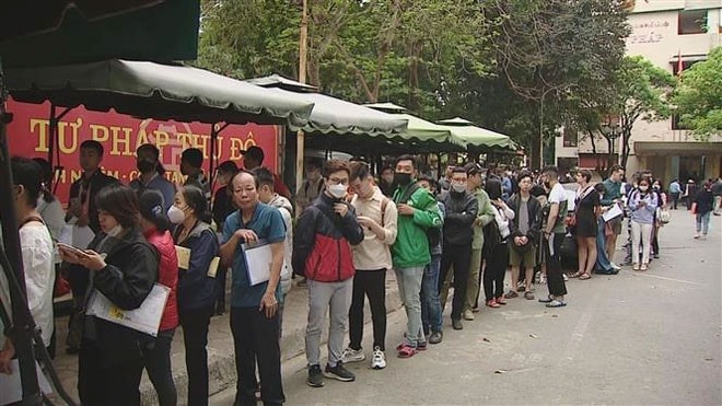 Người dân Hà Nội xếp hàng chờ lấy số vào làm thủ tục cấp phiếu lý lịch tư pháp. (Ảnh: TTXVN)