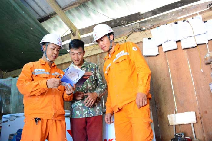 Cán bộ Điện lực Điện Biên Đông hướng dẫn người dân sử dụng thiết bị điện. Ảnh: VN